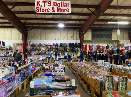 Interior of K.T.'s Dollar Store, featuring shelves of clothing, toys, and various merchandise in a spacious layout.