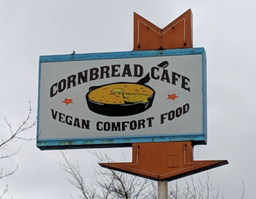 Sign for Cornbread Cafe featuring a skillet of cornbread and the text "Vegan Comfort Food."