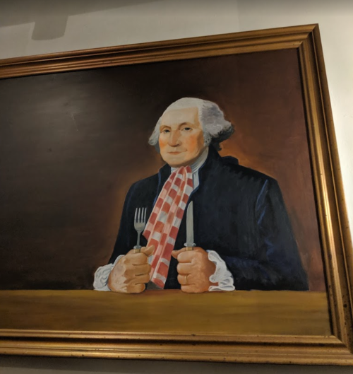 A portrait of a man with white hair, holding a fork and knife, dressed in 18th-century attire with a checkered cravat.