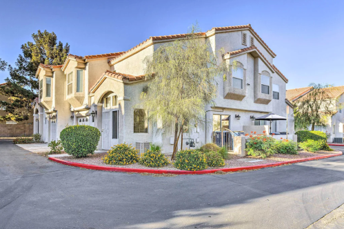 A corner view of a two-story residential building with landscaping and a clear blue sky.