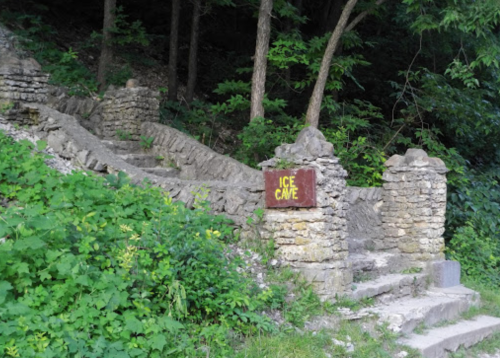 Stone steps lead to an entrance marked "Ice Cave," surrounded by lush greenery and trees.