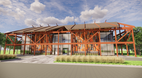 Modern building with a striking orange frame, large windows, and a landscaped entrance under a blue sky.