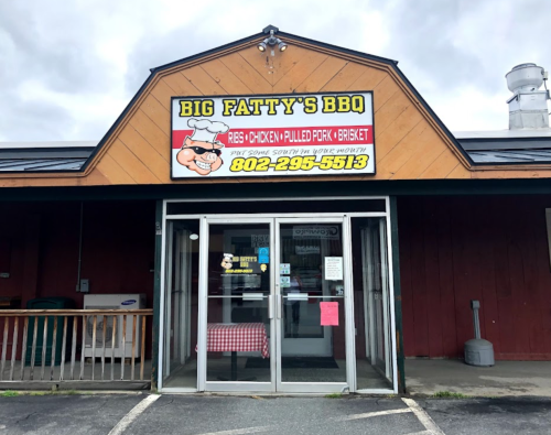 Exterior of Big Fatty's BBQ restaurant, featuring a sign with menu items and a welcoming entrance.