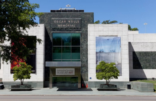 Front view of the Birmingham Museum of Art, featuring the Oscar Wells Memorial sign and large banners on the facade.