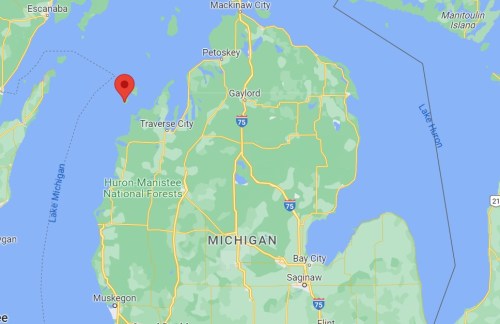 Map of Michigan highlighting a location near Traverse City, with surrounding lakes and forests visible.