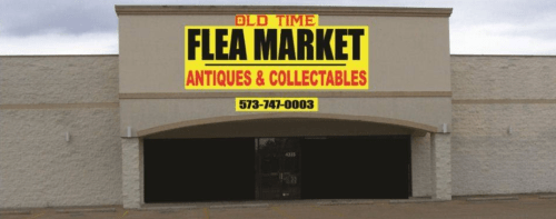 Sign for "Old Time Flea Market" featuring antiques and collectibles, with a phone number displayed.