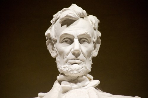 Close-up of a white marble statue of Abraham Lincoln, showcasing his facial features and iconic beard.