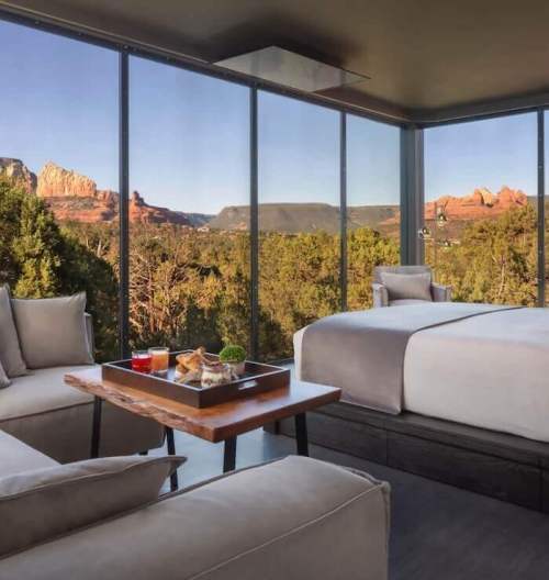 A modern room with large windows showcasing a scenic view of red rock formations and greenery outside.