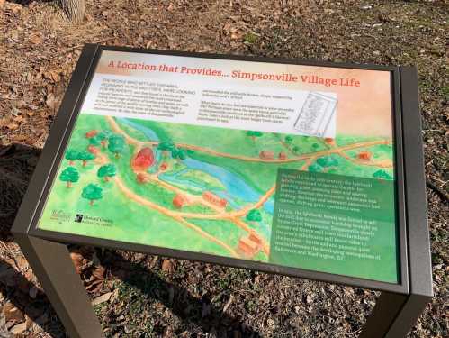 Informational sign about Simpsonville Village life, featuring a colorful map and text about the area's history and resources.