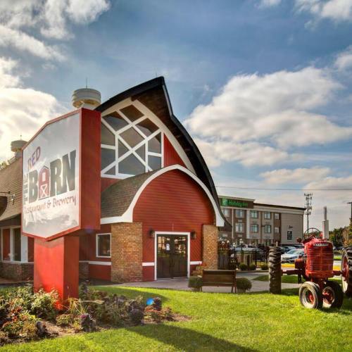 Exterior of Red Barn Restaurant & Brewery, featuring a red barn-style building and a vintage tractor in the foreground.