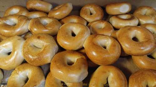 A close-up of freshly baked bagels, golden brown and arranged in a box.