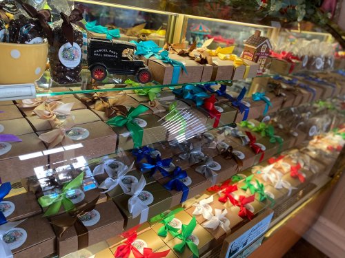 A display of neatly arranged gift boxes with colorful ribbons in a shop window.