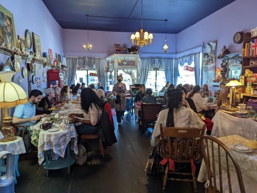 A cozy café filled with people dining, vintage decor, and soft lighting, creating a warm and inviting atmosphere.