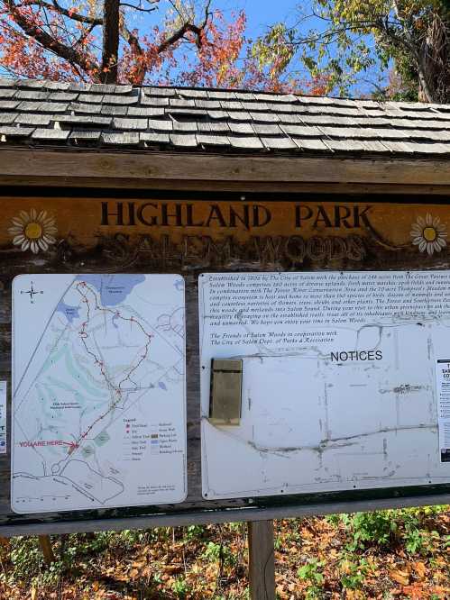 Sign for Highland Park, Salem Woods, featuring a map and notices about the area, surrounded by autumn foliage.