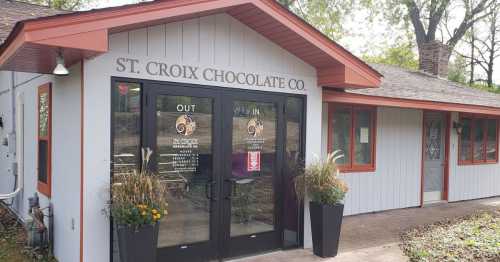 Exterior of St. Croix Chocolate Co. with a welcoming entrance and flower pots on either side.