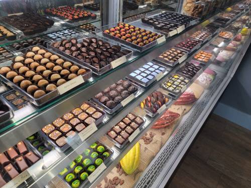 A display case filled with an assortment of beautifully arranged chocolates and confections.