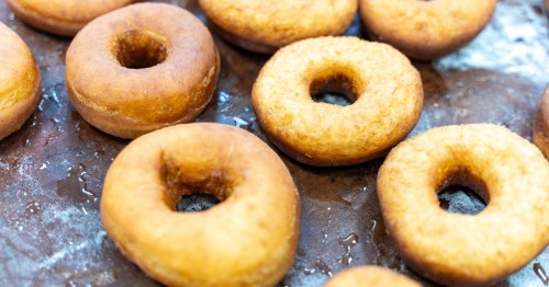 donuts just out of the frier on a dark background