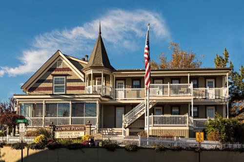 Historic building with a pointed turret, balconies, and an American flag, set against a blue sky.
