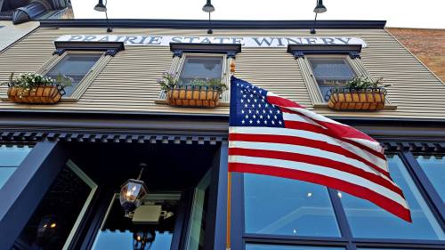 Exterior of Prairie State Winery with an American flag and flower boxes under the windows.