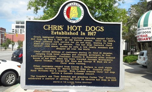Historical marker for Chris' Hot Dogs, established in 1917, detailing its founder and significance in Montgomery, Alabama.