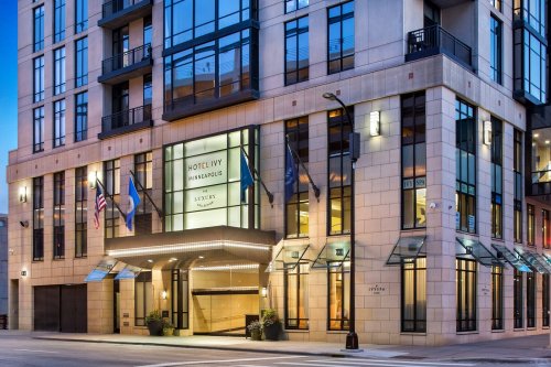 Exterior view of Hotel Ivy in Minneapolis, showcasing modern architecture and illuminated entrance at dusk.