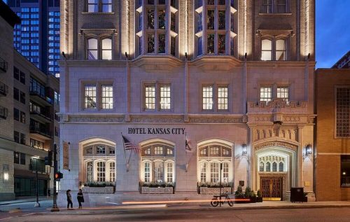 Exterior view of Hotel Kansas City, featuring elegant architecture and illuminated windows at dusk.