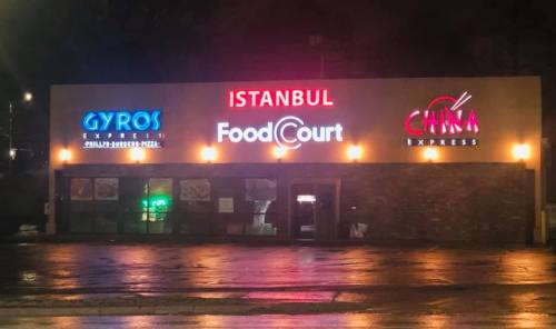 Signage for Istanbul Food Court featuring Gyros Express and China Express, illuminated at night.
