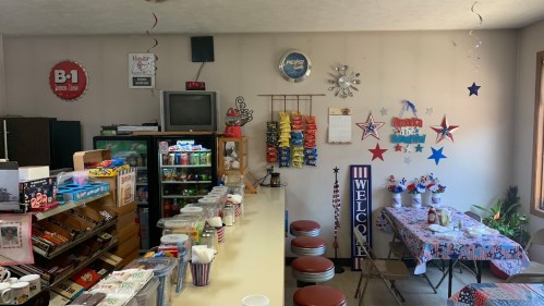 A cozy diner interior with a counter, snacks, decorations, and a table set for dining, featuring a welcoming atmosphere.