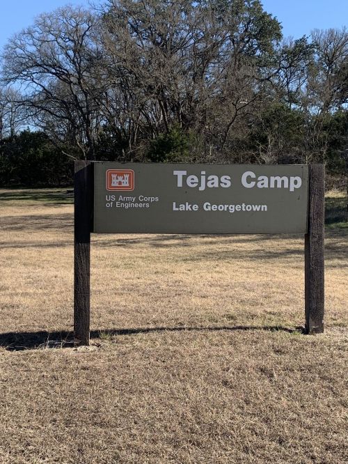 Sign for Tejas Camp at Lake Georgetown, featuring the US Army Corps of Engineers logo, set in a grassy area.