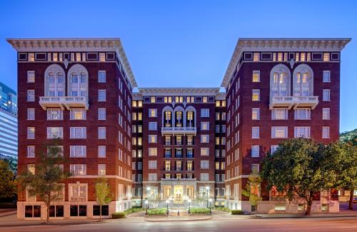 Historic brick building with symmetrical architecture, featuring large windows and decorative elements, illuminated at dusk.