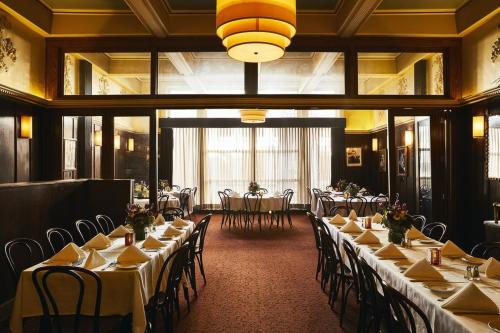 Elegant restaurant interior with tables set for dining, featuring floral centerpieces and warm lighting.