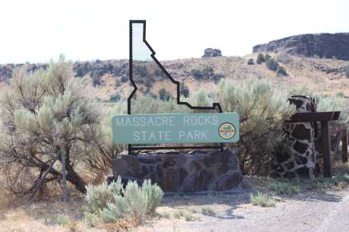 Sign for Massacre Rocks State Park in Idaho, featuring a stylized outline of the state and surrounding sagebrush.