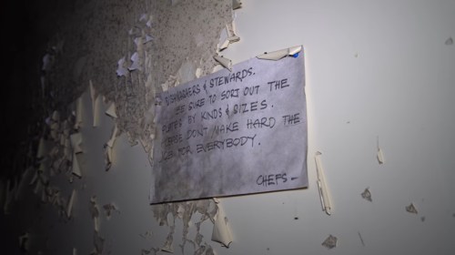 A handwritten note on a wall, requesting dishwashers and stewards to sort out the chefs by kinds and sizes.