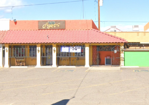 A colorful storefront with a red tile roof, featuring a sign that reads "Agie's" and a green wall on the right.