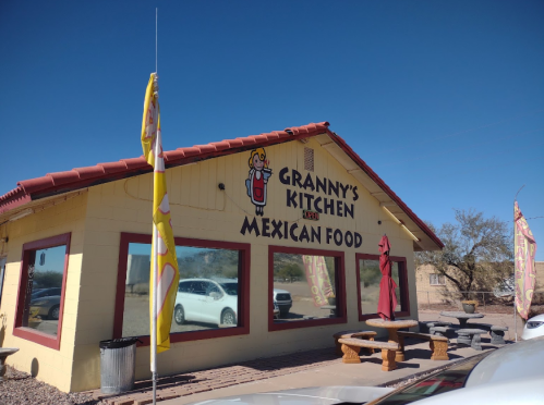 A colorful restaurant exterior with a sign reading "Granny's Kitchen Mexican Food" under a clear blue sky.