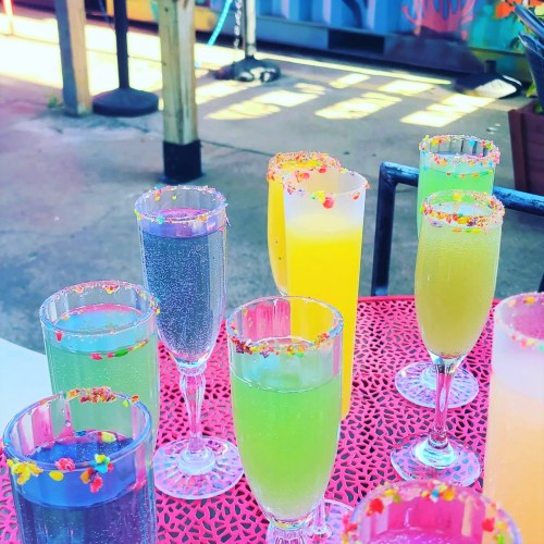 A colorful assortment of drinks with festive rim decorations on a vibrant table.