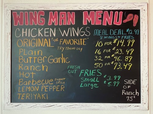 Chalkboard menu listing chicken wing flavors and prices, including meal deals and sides.