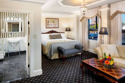 Luxurious hotel room featuring a king bed, elegant decor, a sitting area, and a stylish bathroom.
