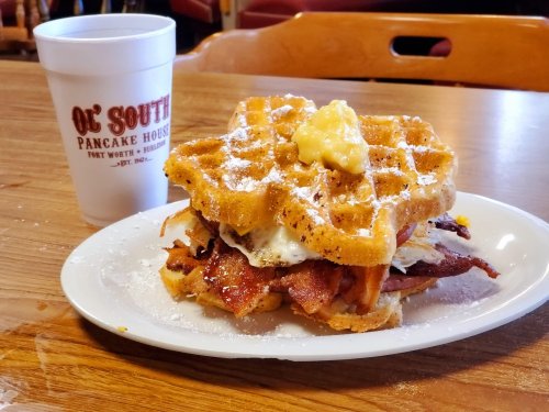 A waffle sandwich with bacon, egg, and butter, served with a cup from Ol' South Pancake House.