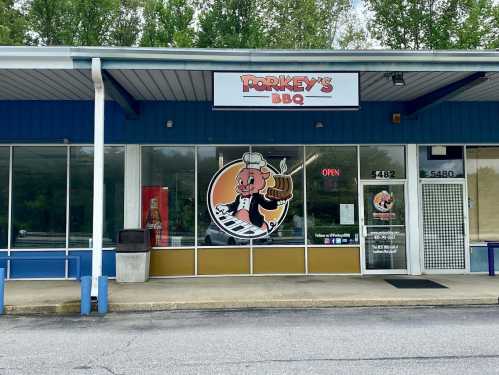 Exterior of Porkey's BBQ restaurant, featuring a cartoon pig chef logo and an "OPEN" sign in the window.