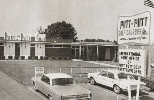 Black and white photo of the Putt-Putt Golf Courses headquarters with vintage cars parked outside.