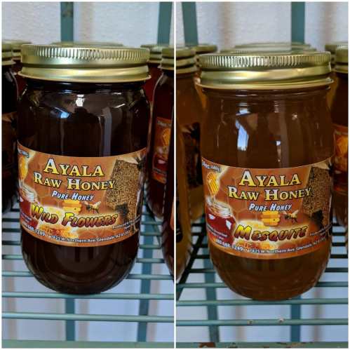 Two jars of Ayala Raw Honey labeled "Wild Flowers" and "Mesquite," displayed on a shelf.