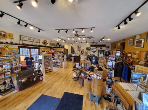 A spacious gift shop with wooden floors, shelves of merchandise, and various decor items displayed throughout.