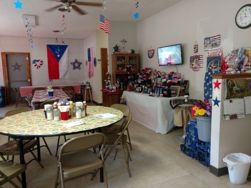 A decorated room with a round table, patriotic decor, and a TV displaying a scene, creating a festive atmosphere.
