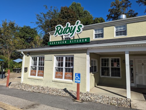 Exterior of Ruby's Southern Kitchen, a light green building with a sign, windows displaying "Help Wanted" notices.