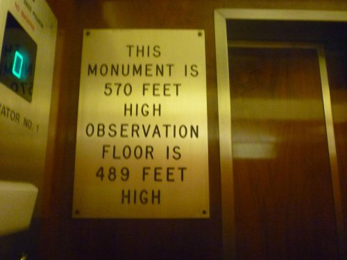 Sign in an elevator stating the monument's height (570 feet) and observation floor height (489 feet).