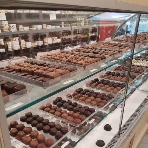 A display case filled with an assortment of chocolate truffles and confections in various shapes and sizes.