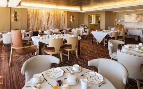 Elegant restaurant interior with neatly set tables, soft lighting, and modern decor.