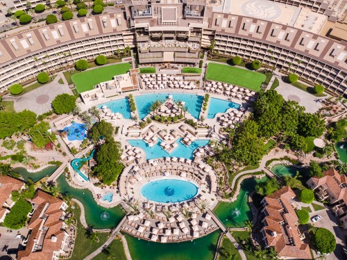 Aerial view of a resort featuring multiple pools, lounge chairs, and landscaped gardens.