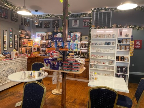 A cozy café interior with decorated shelves, tables, and a variety of snacks and drinks on display.